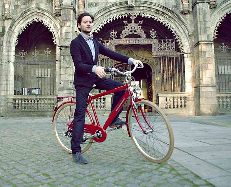 barbat in costum pe bicicleta