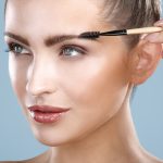 Closeup beautiful woman with eyebrow brush tool